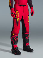 Alpinestars 2026 Supertech Scenz Pants, Motocross Pants, Red Black and Yellow, featuring yellow Alpinestars logos and black panels, worn with matching red jersey, red gloves, and black motocross boots.