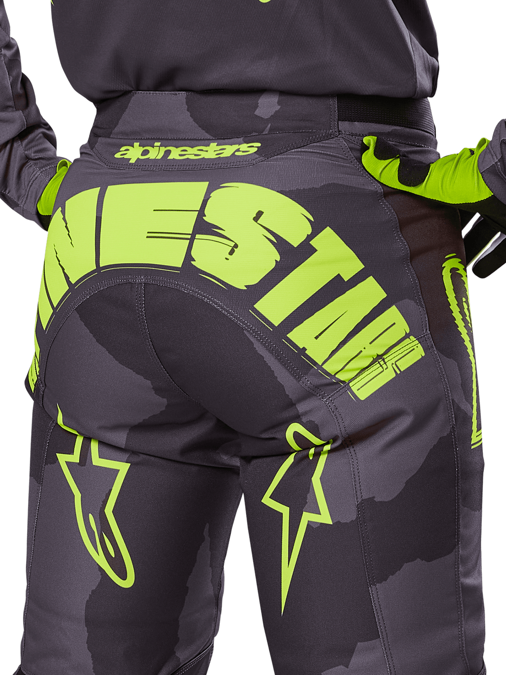Alpinestars Racer Hollow Pants 2025, pantalones de motocross, camuflaje oscuro y amarillo flúor, con un gran logotipo de Alpinestars en amarillo en la parte trasera, patrón de camuflaje táctico con detalles en amarillo vibrante y construcción duradera para carreras off-road.