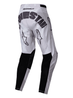 Alpinestars 2025 Racer Hollow Pants, pantalones de motocross, marrón camuflaje claro, vista posterior con la marca Alpinestars en negro en el asiento, logotipos de estrellas en la parte trasera de los muslos y paneles reforzados negros en la parte inferior de las piernas, diseño deportivo para todoterreno con un patrón de camuflaje gris claro