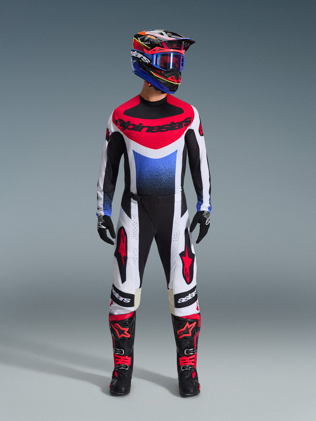 Alpinestars 2026 Techstar Knif Pants, Motocross Pants, Black White and Red, worn as part of a full racing gear set with matching jersey and helmet, featuring red star logos on the thighs and a sleek athletic fit for off-road racing