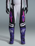 Alpinestars 2026 Techstar Knif Pants, Motocross Racing Pants, Black, White, and Purple with Pink and Blue accents, worn with purple racing boots and black gloves, featuring ergonomic racing cut and bold logo graphics for off-road performance