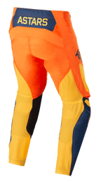 Alpinestars Techstar Factory Pants, pantalones de motocross, naranja, azul oscuro y amarillo cálido, vista trasera que muestra el logotipo ASTARS amarillo en un panel posterior azul oscuro, chasis naranja vibrante con malla amarilla transpirable en la parte inferior de las piernas y detalles azules