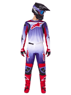 Alpinestars 2025 Fluid Wurx Gear Set, piloto de motocross con jersey y pantalones en morado, blanco y rojo brillante, casco negro con gafas azules, botas de motocross rojas y guantes a juego, diseño de competición atlético para un rendimiento off-road