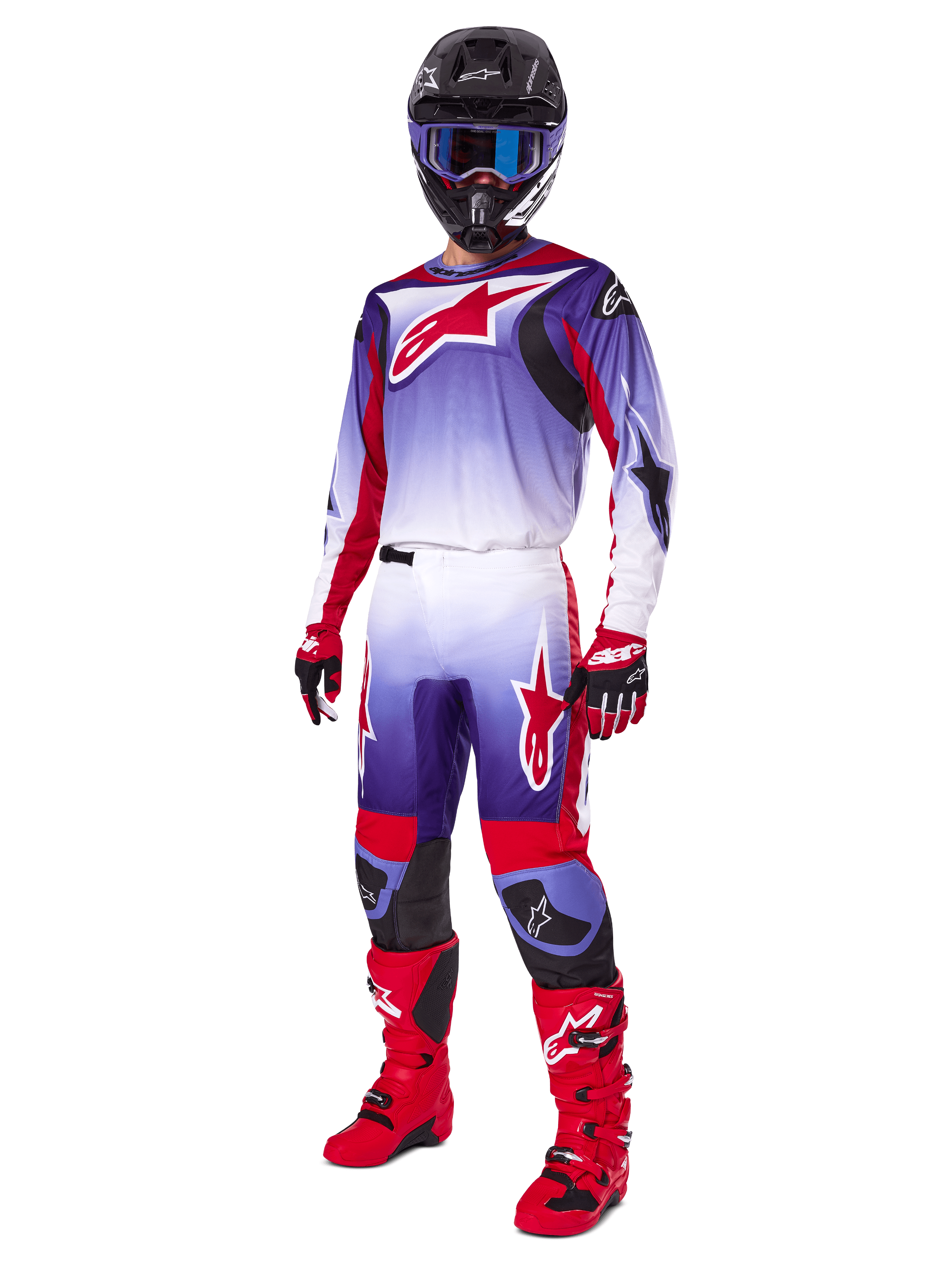 Piloto de motocross con equipamiento completo de carreras, pantalones Fluid Wurx 2025 y jersey a juego en morado, rojo brillante y blanco, logotipo grande de Alpinestars en rojo, botas y guantes rojos, casco negro con gafas azules, conjunto coordinado para carreras off-road