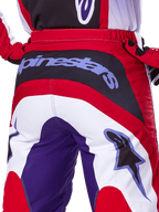 Alpinestars 2025 Fluid Wurx Pants, pantalones de motocross, púrpura y rojo brillante, primer plano de la parte trasera con la marca Alpinestars en el panel negro del asiento, diseño de bloques de colores rojo, blanco y púrpura, equipamiento profesional para carreras off-road