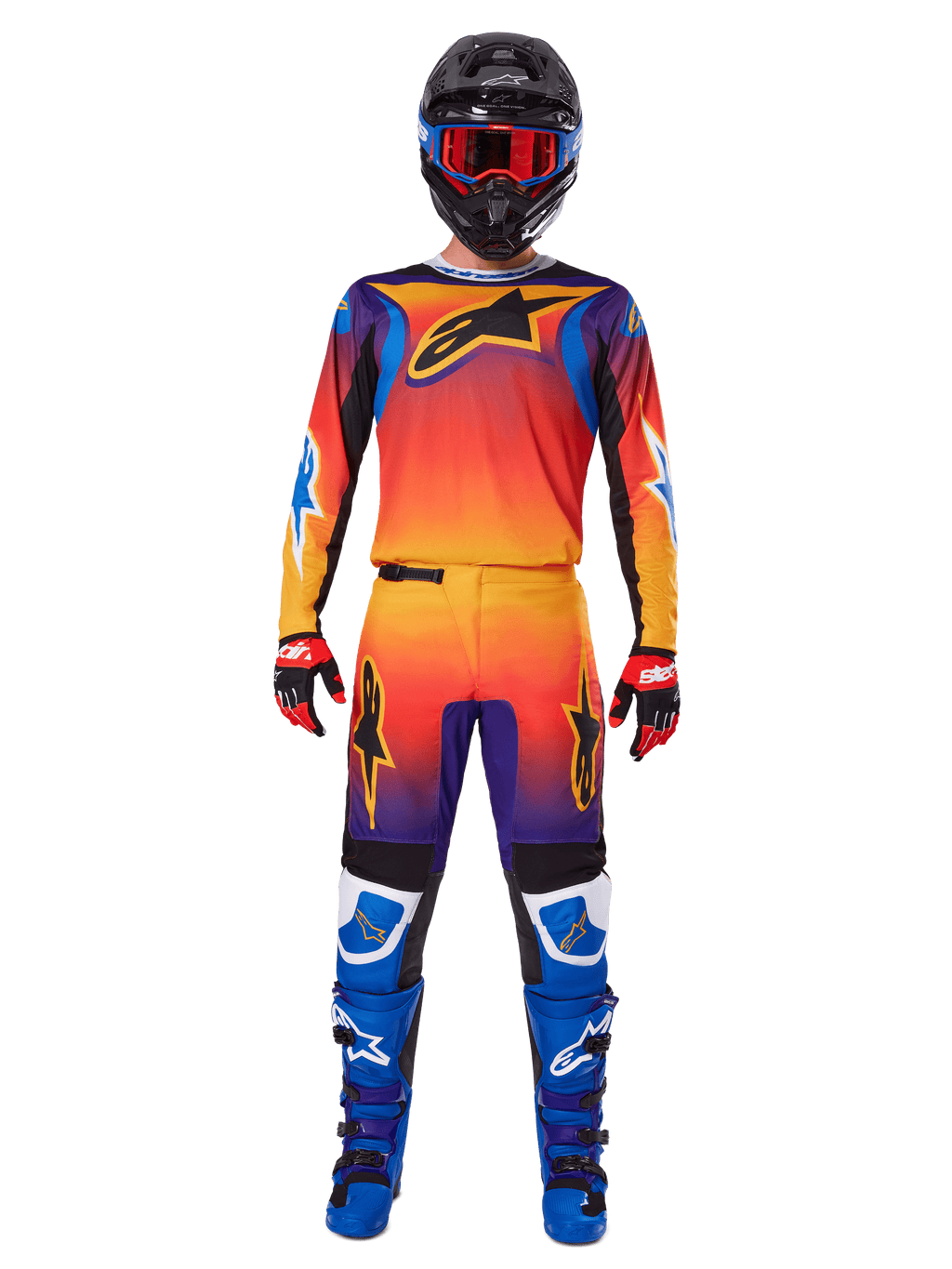 Pantalones Alpinestars Fluid Wurx 2025, pantalones de motocross, degradado multicolor en naranja, amarillo y púrpura, usados con el jersey a juego, casco negro con gafas azules, guantes rojos y negros, y botas azules, equipo de motocross coordinado.