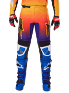 Alpinestars Pantalones Fluid Wurx 2025, pantalones de motocross, multicolor con degradado de naranja a morado y paneles azules, combinados con botas azules y moradas y guantes rojos y negros, vista frontal con el logo de la estrella