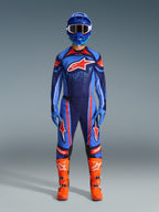 Alpinestars 2026 Techstar Nomur gear set, Motocross rider in full racing kit, Dark Navy with Orange and UCLA Blue accents, matching jersey and pants with large logos, blue helmet and bright orange boots, coordinated off-road competition gear.