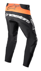 Alpinestars Techstar Sein Pants 2023, pantalones de motocross, negro y naranja brillante, vista trasera que muestra el panel naranja de la cintura con logo negro, marca Alpinestars grande en blanco sobre la parte trasera y construcción textil reforzada para carreras todoterreno