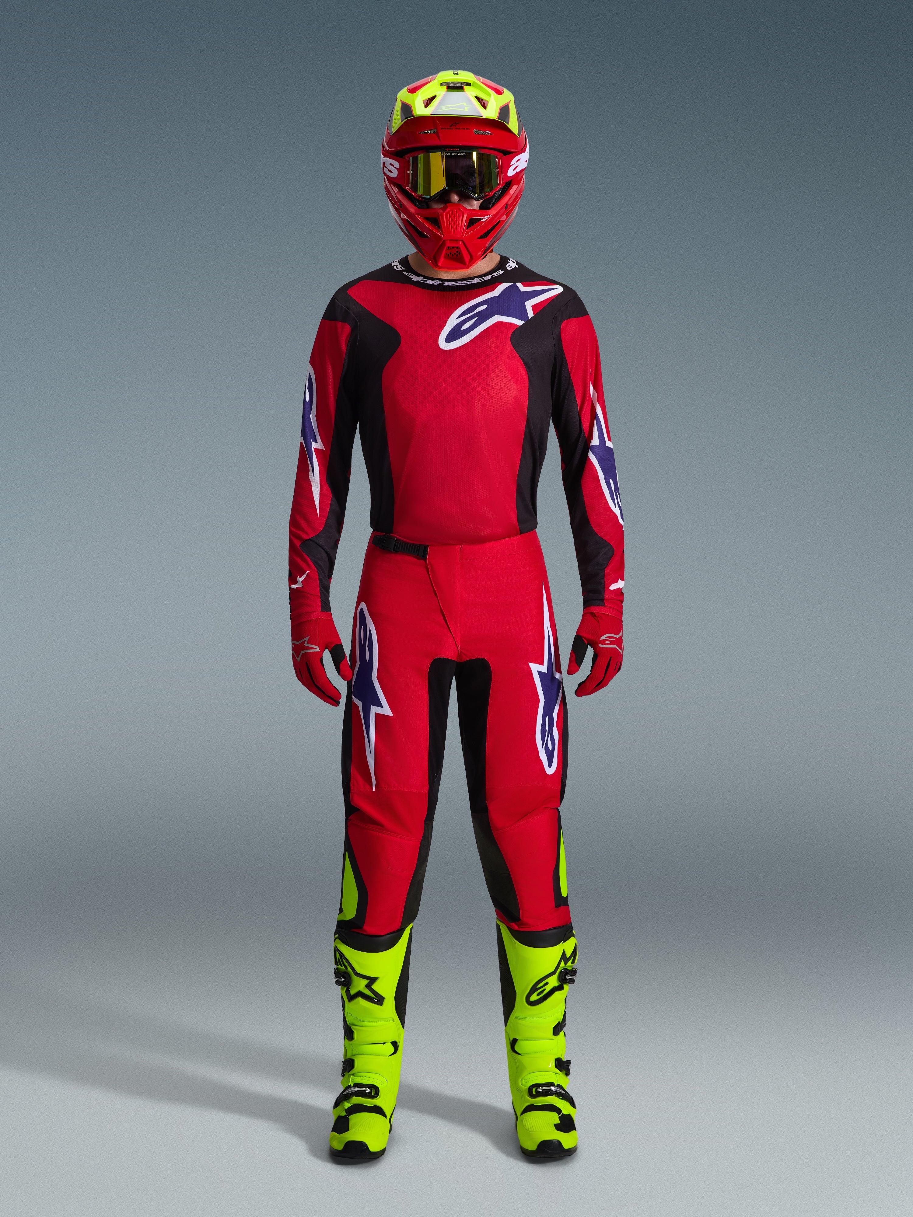 Alpinestars 2026 Fluid Grid Gear Set, conjunto de motocross, rojo y negro, equipo de pilotaje completo con jersey y pantalones rojos con logotipos azules y blancos, casco rojo a juego con detalles amarillo neón y botas amarillo neón, diseño de alto rendimiento para carreras off-road