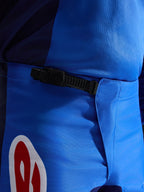 Alpinestars 2026 Fluid Grid Pants, pantalones de motocross, azul y rojo, vista de primer plano del sistema de cierre de trinquete negro en la cintura, polifabric azul duradero con detalle de logotipo en rojo y blanco, diseñado para el rendimiento off-road