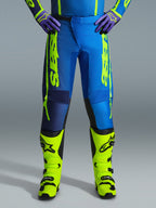 Pantalones Alpinestars 2026 Fluid Apex, pantalones de motocross, azul y amarillo fluo, combinados con botas amarillo fluo a juego y guantes morados, marca llamativa en amarillo en los laterales, diseño ergonómico para competición off-road