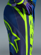 Alpinestars 2026 Fluid Apex Pants, pantalones de motocross, azul y amarillo flúor, primer plano del lateral y la cadera con el logotipo de Alpinestars en amarillo neón, material de polifabric duradero para conducción off-road, parte de un conjunto de equipamiento a juego