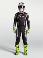 Pantalones Alpinestars Fluid Apex V2 de motocross para hombre, negros y plateados, con botas amarillo neón y jersey técnico