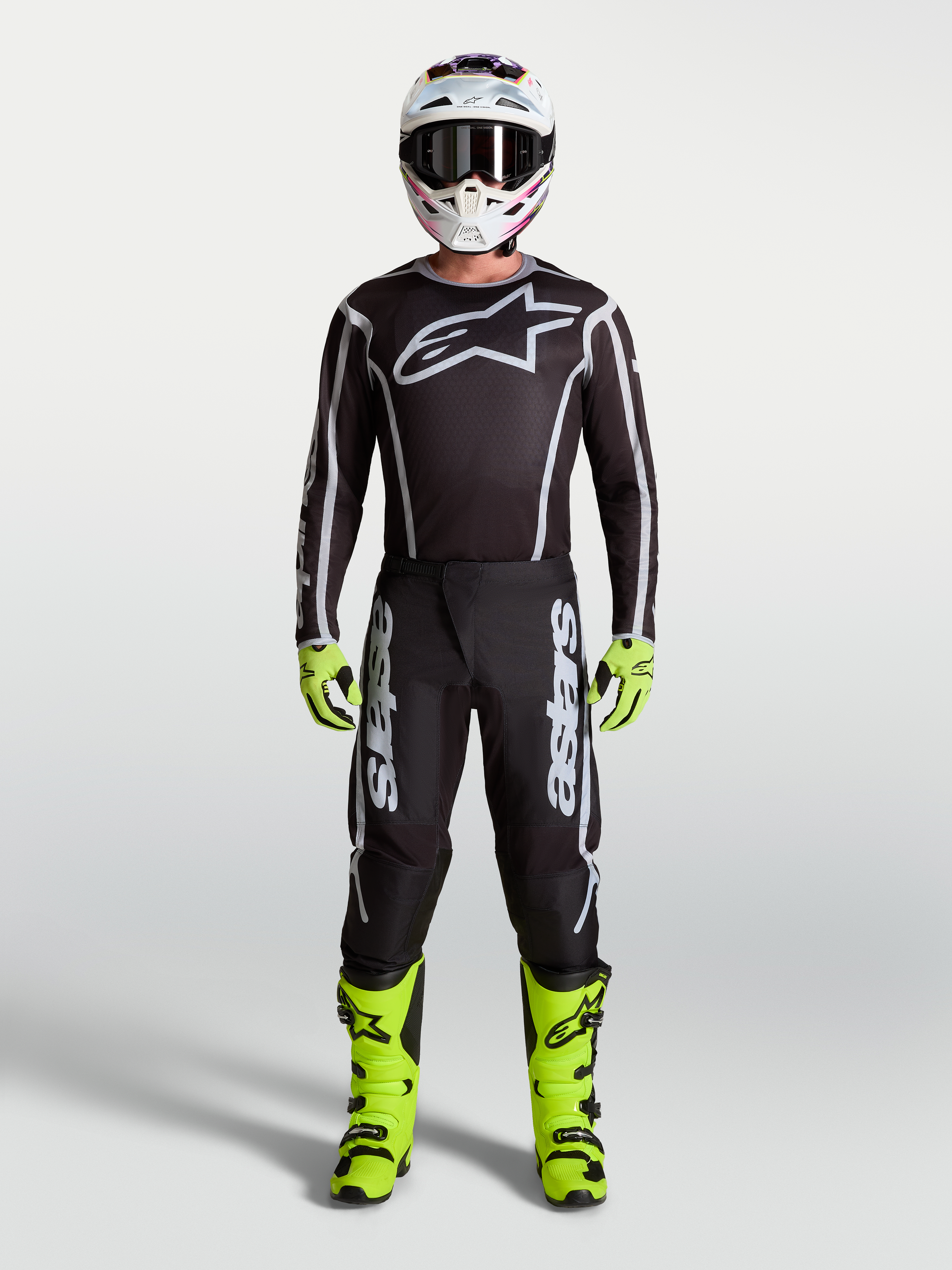 Pantalones Alpinestars Fluid Apex V2 de motocross para hombre, negros y plateados, con botas amarillo neón y jersey técnico