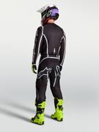 Alpinestars Men's Fluid Apex V2 Motocross Pants in Black and Silver, shown from behind with matching jersey and neon boots.