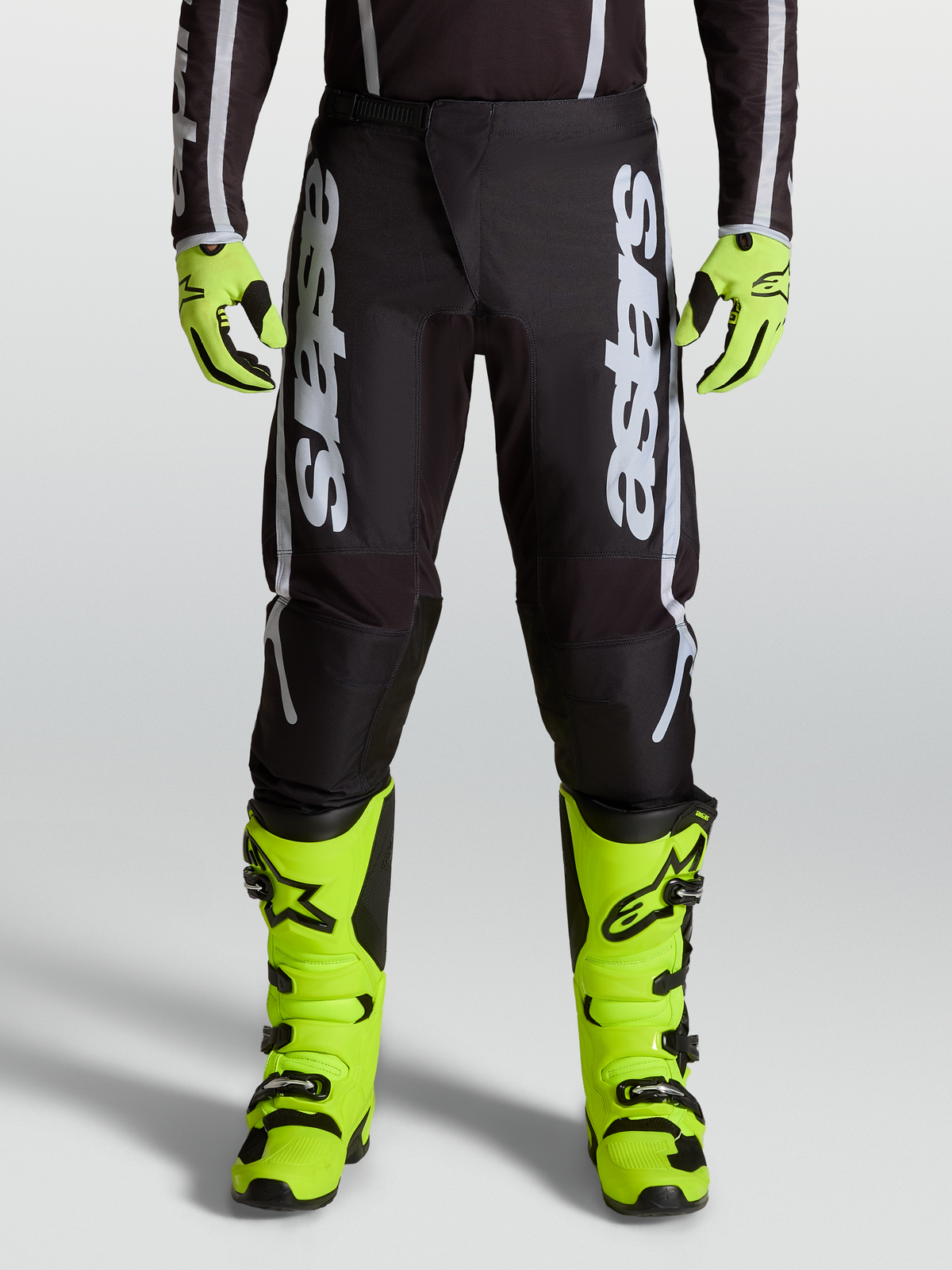 Alpinestars 2027 Fluid Apex V2 Men's Motocross Pants in Black and Silver, featuring ergonomic stretch panels on-model.