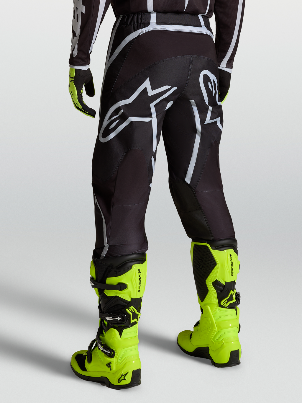 Alpinestars Pantalones Fluid Apex V2, pantalones de motocross para hombre, negros y plateados, usados con botas amarillas fluorescentes
