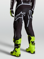 Alpinestars Pantalones Fluid Apex V2, pantalones de motocross para hombre, negros y plateados, usados con botas amarillas fluorescentes