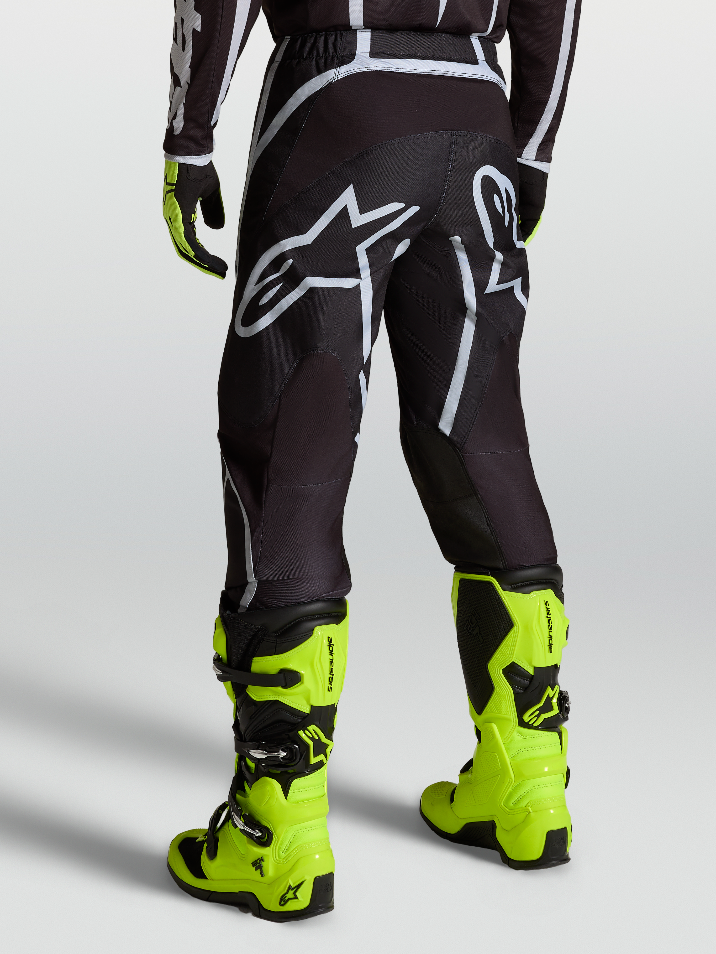 Alpinestars Pantalones Fluid Apex V2, pantalones de motocross para hombre, negros y plateados, usados con botas amarillas fluorescentes
