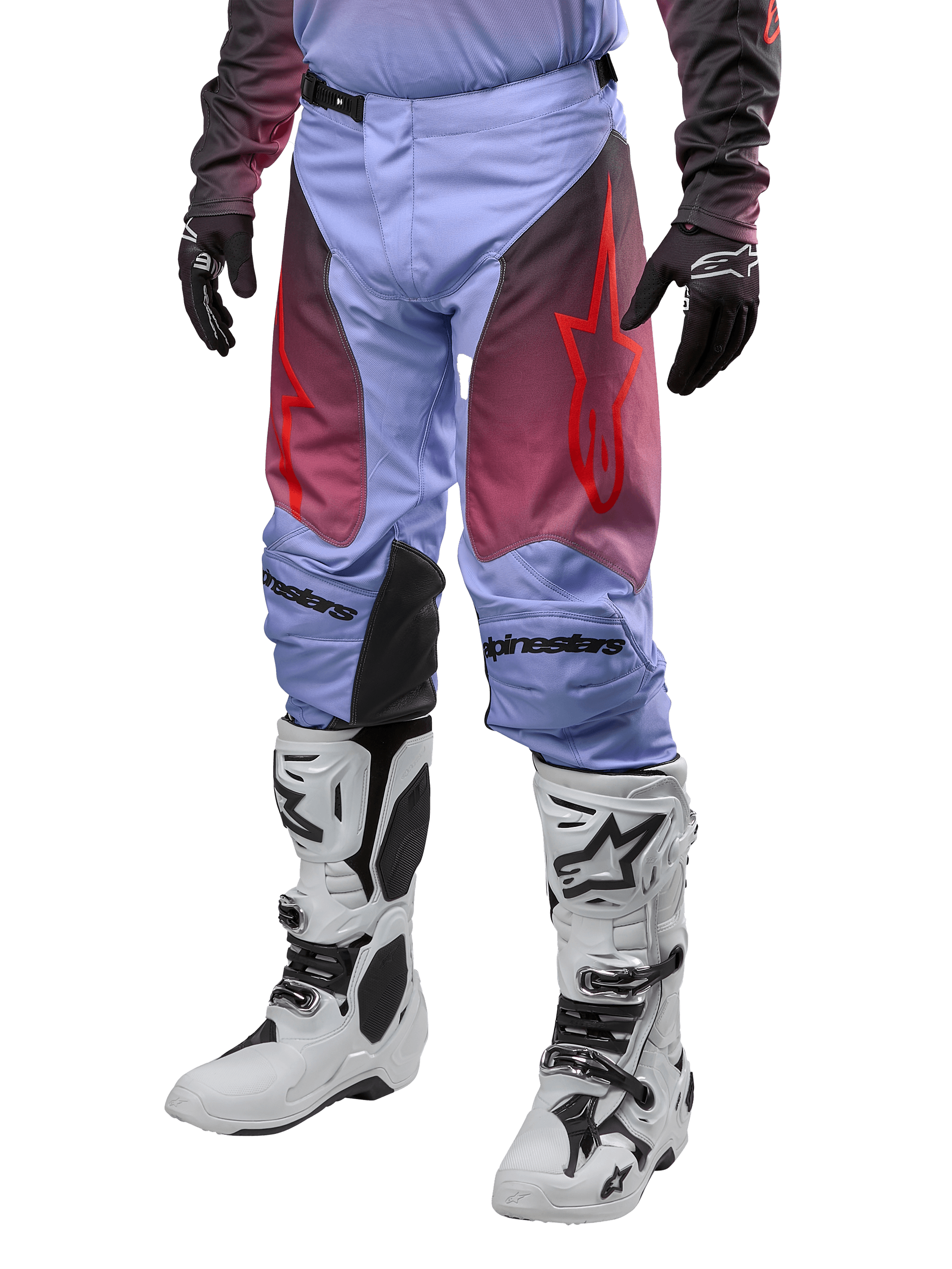Alpinestars Racer Hoen Pants 2024, pantalones de motocross, morado Lavan y negro con gráficos rojos, con logotipos de estrella roja en los muslos y letras negras en las rodillas, usados con botas blancas y negras y guantes negros