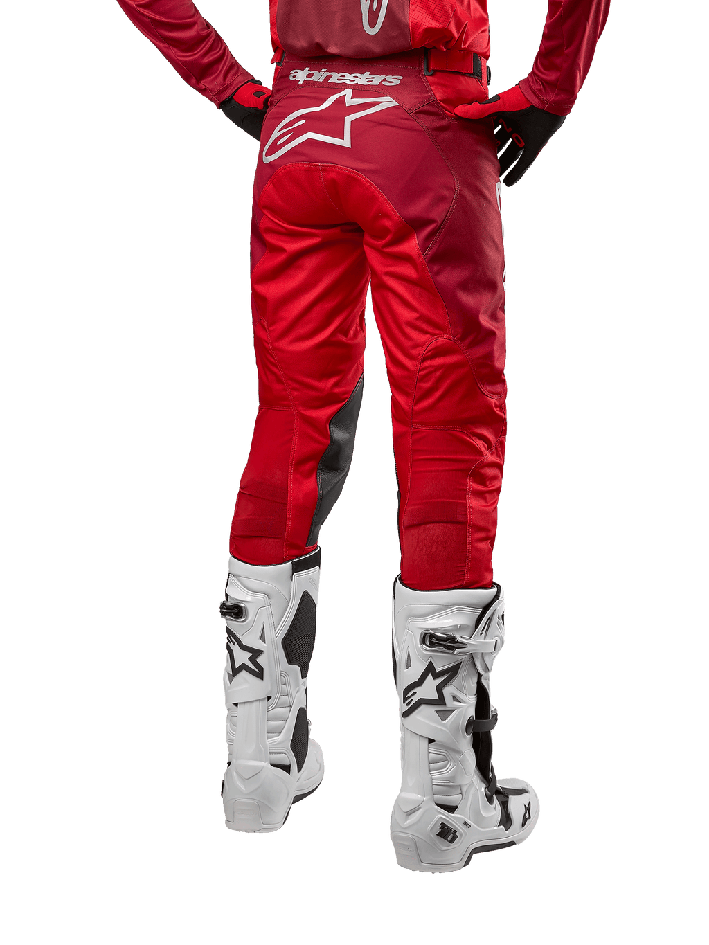 Alpinestars 2024 Racer Hoen Pants, pantalones de motocross, Mars Red Burgundy, vista trasera que muestra un gran logotipo Astar blanco en la parte posterior, paneles interiores negros en las rodillas, combinados con botas de motocross blancas, equipamiento de alto rendimiento para off-road