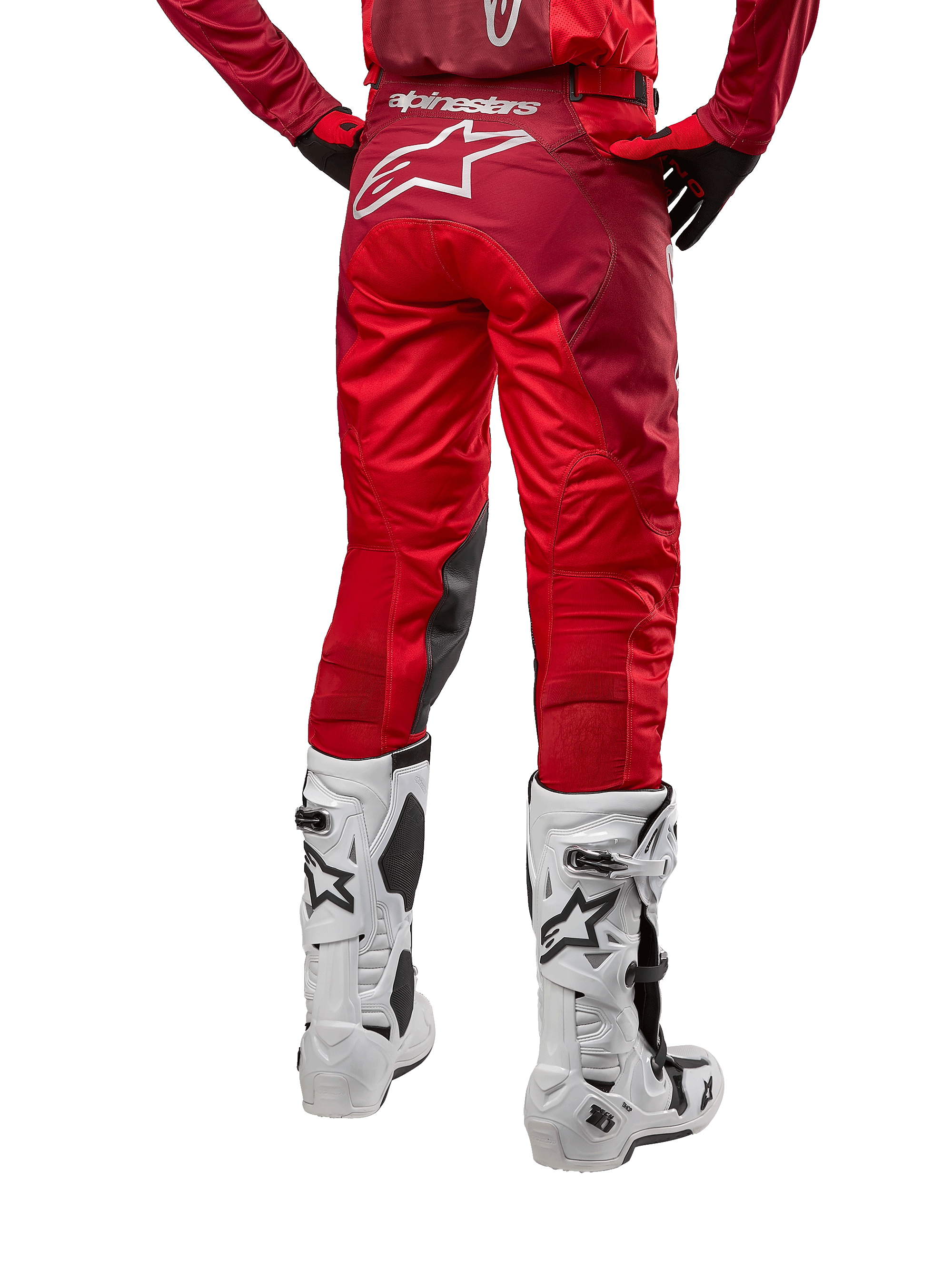 Alpinestars 2024 Racer Hoen Pants, pantalones de motocross, Mars Red Burgundy, vista trasera que muestra un gran logotipo Astar blanco en la parte posterior, paneles interiores negros en las rodillas, combinados con botas de motocross blancas, equipamiento de alto rendimiento para off-road