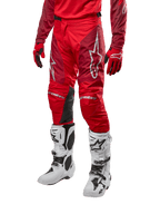 Pantalones Alpinestars Racer Hoen 2024, pantalones de motocross, en rojo marte y granate, combinados con jersey y guantes rojos a juego y botas blancas, con paneles de cuero negro en las rodillas y logotipos blancos, equipo técnico duradero para competiciones todoterreno