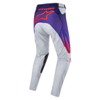 Alpinestars 2024 Racer Hoen Pants, pantalones de motocross para hombre, gris claro con detalles en naranja intenso y negro, vista trasera que destaca el logo en naranja sobre fondo púrpura, diseño ergonómico y material ligero para off-road