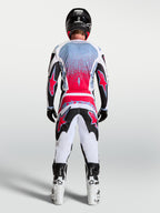 Alpinestars Pantalones Fluid Drag, pantalones de motocross para hombre, negros, blancos y rojo flúor, vista trasera de piloto con equipo completo, patrón 3D ergonómico