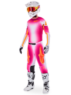 Piloto de motocross con el conjunto de equipamiento Alpinestars Supertech AFD MIG Limited Edition, jersey y pantalones con degradado en rosa flúor, blanco y naranja, casco blanco con gafas naranjas, botas blancas y negras, indumentaria profesional para conducción en tierra