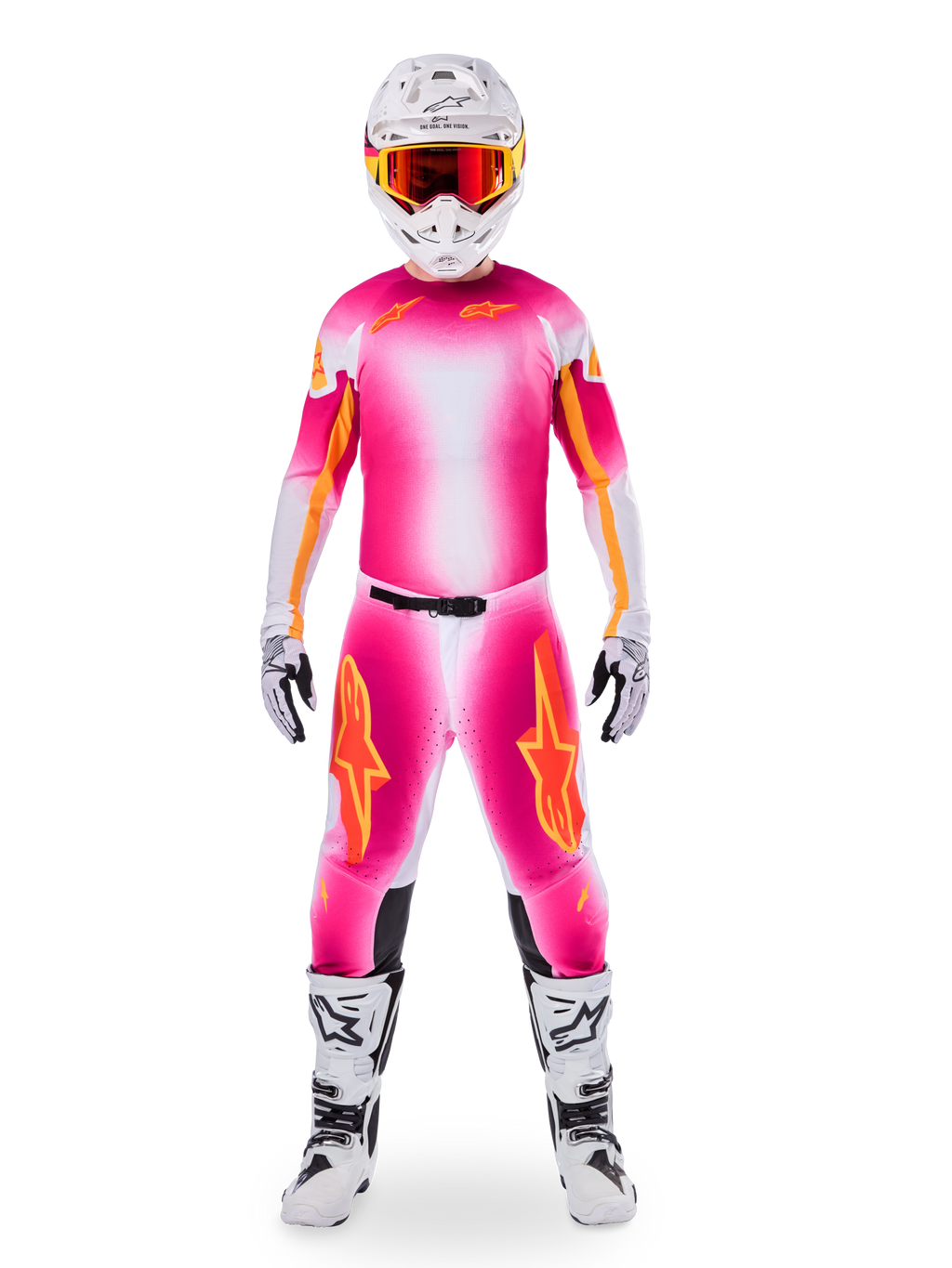 Piloto de motocross con el conjunto de equipamiento Alpinestars Limited Edition Supertech AFD MIG, camiseta y pantalones con degradado en rosa flúor y blanco con logotipos naranjas, casco blanco con gafas rojas, botas y guantes blancos y negros, atuendo de carreras profesional coordinado.