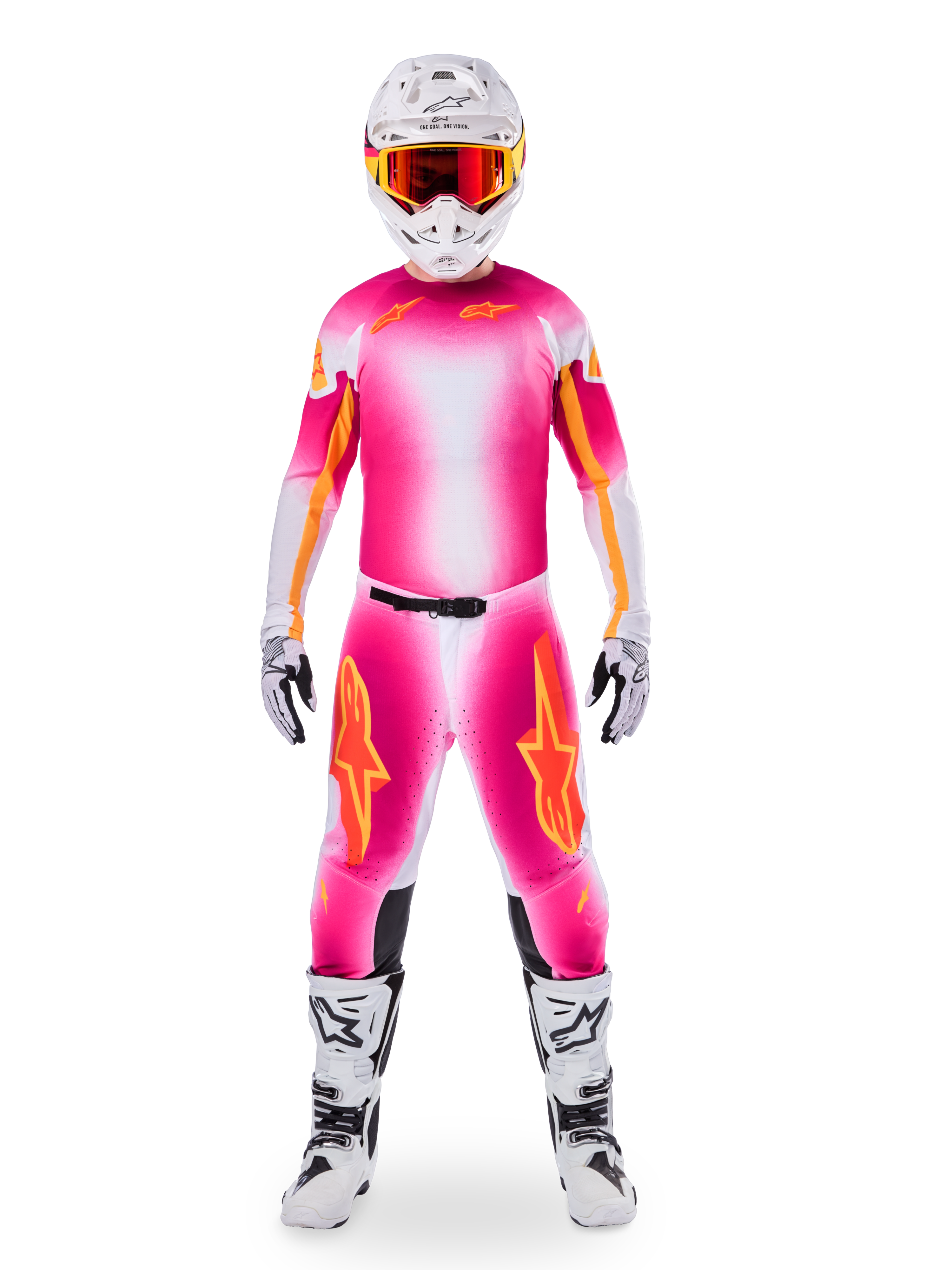 Piloto de motocross con el conjunto de equipamiento Alpinestars Limited Edition Supertech AFD MIG, camiseta y pantalones con degradado en rosa flúor y blanco con logotipos naranjas, casco blanco con gafas rojas, botas y guantes blancos y negros, atuendo de carreras profesional coordinado.