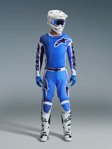Alpinestars 2026 Racer Air Portl Pants, Motocross Pants, Ucla Blue and White, worn as part of a complete racing gear set with a matching jersey, white helmet, blue goggles, and white boots, featuring high-airflow perforated panels and bold branding for off-road performance.