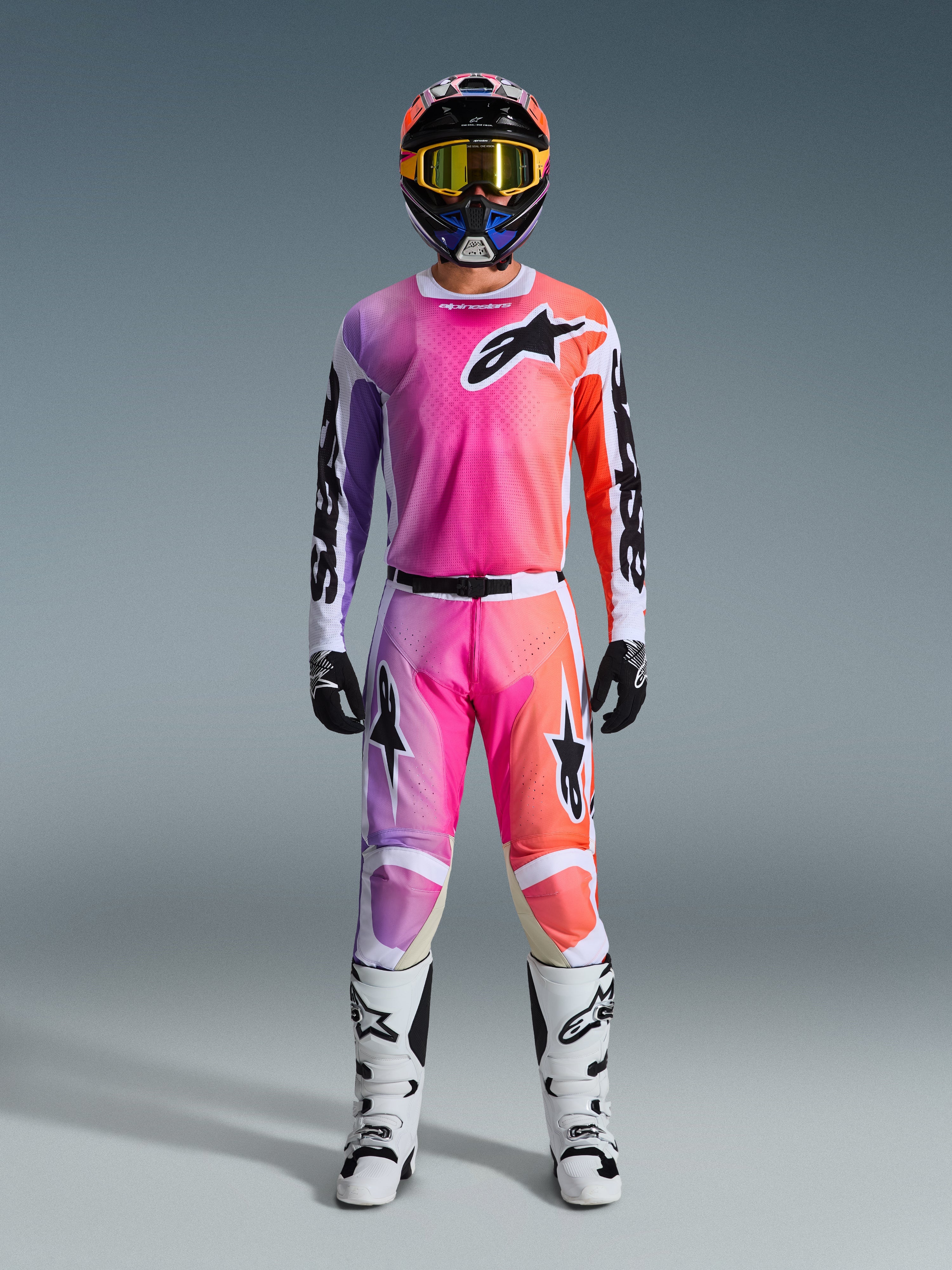 Alpinestars 2026 Racer Air Portl Gear Set, equipo de motocross, rosa, morado y naranja, conjunto completo con casco a juego, gafas amarillas, guantes negros y botas blancas, con el logotipo de la estrella en el pecho y las piernas.