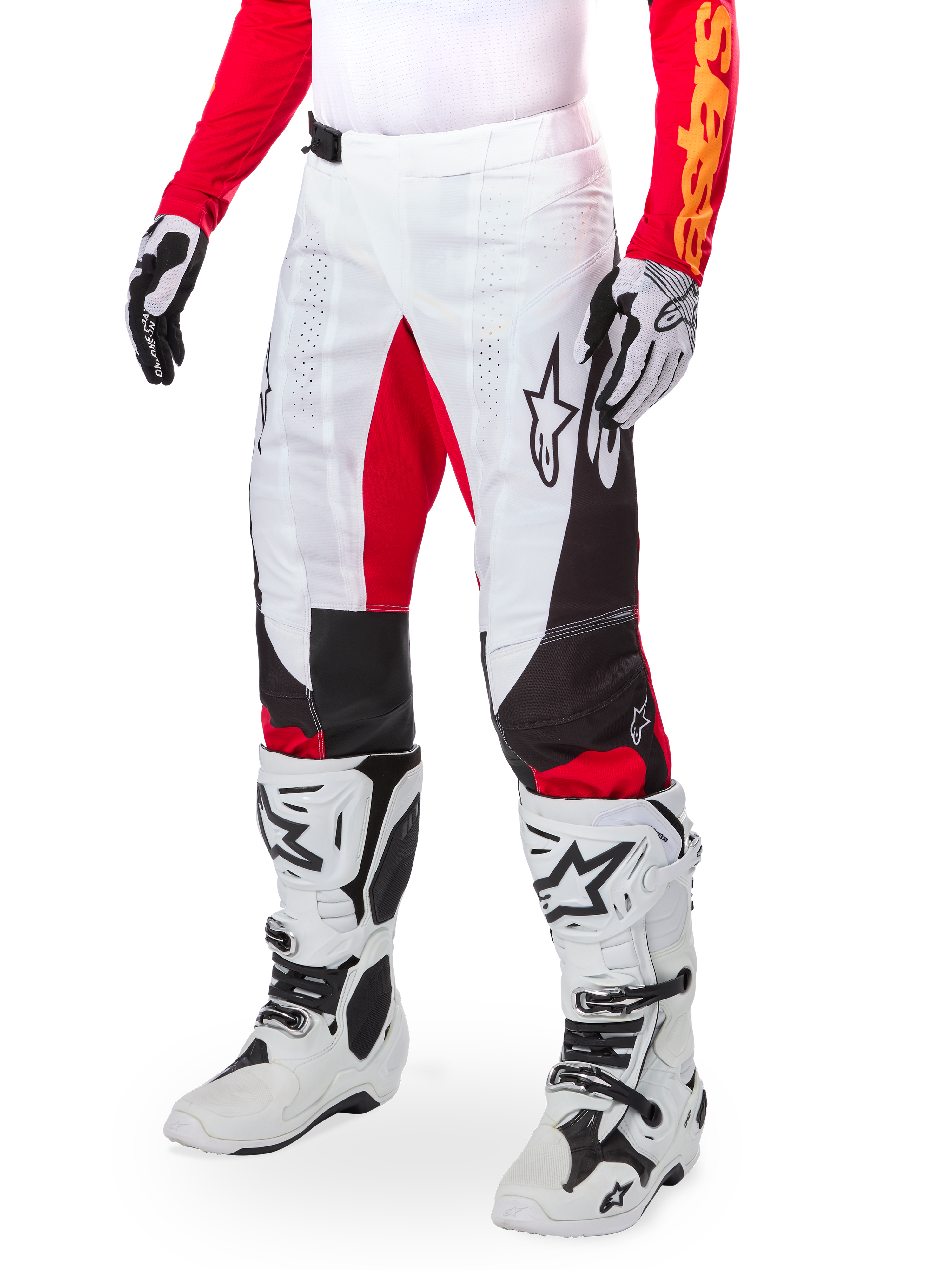 Alpinestars Limited Edition Techstar Deep Pants, pantalones de motocross, blanco, negro y rojo intenso, usados con botas y guantes blancos y negros, con paneles frontales blancos con acentos rojos y detalles laterales en negro, diseñados para carreras todoterreno de alto rendimiento