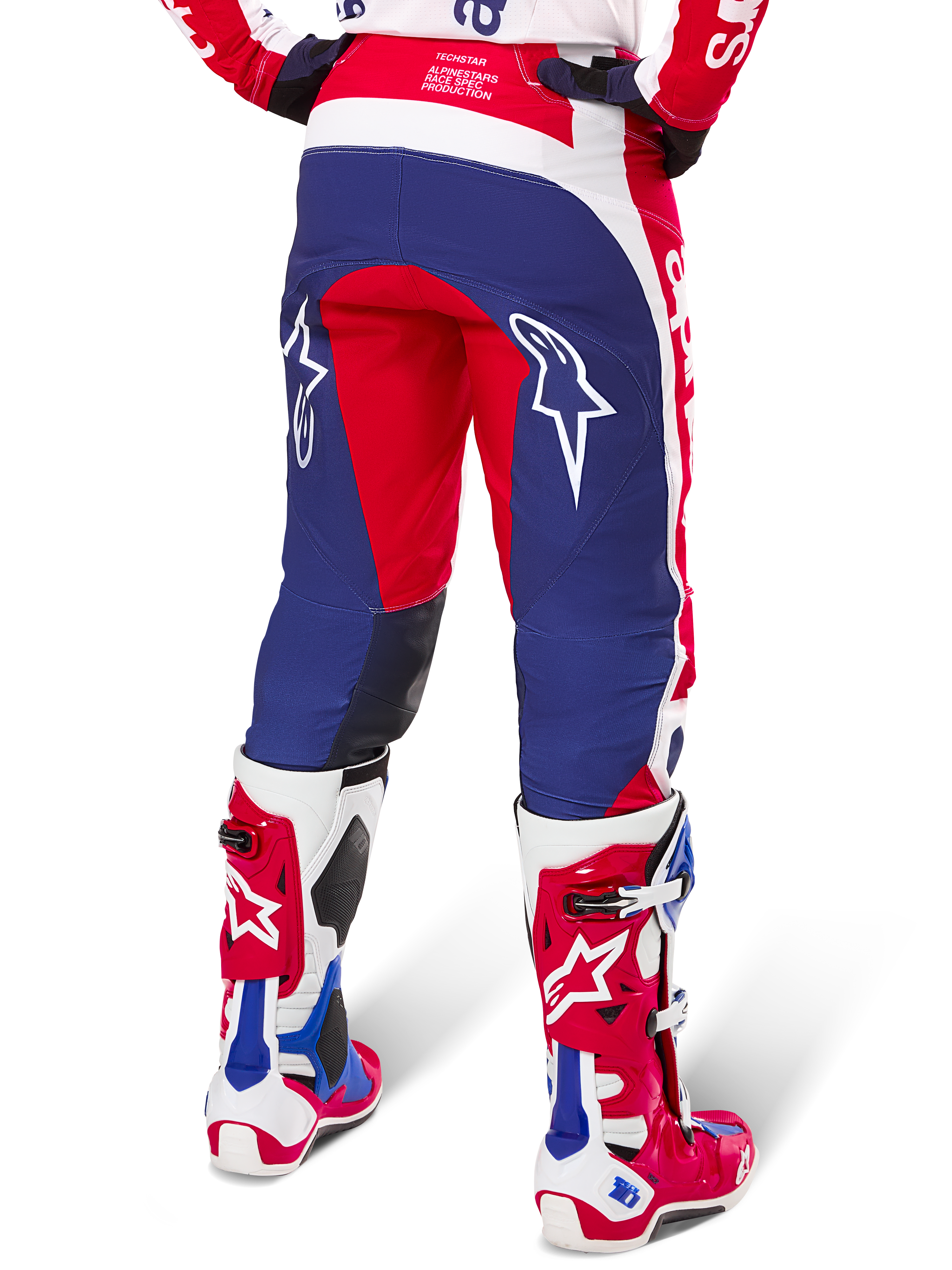 Alpinestars Limited Edition Techstar Fortitude Pants, pantalones de motocross, rojos, blancos y azules, vista trasera con botas rojas y blancas a juego, con logotipos de estrellas blancas en los muslos, diseño duradero de múltiples paneles para carreras profesionales de off-road