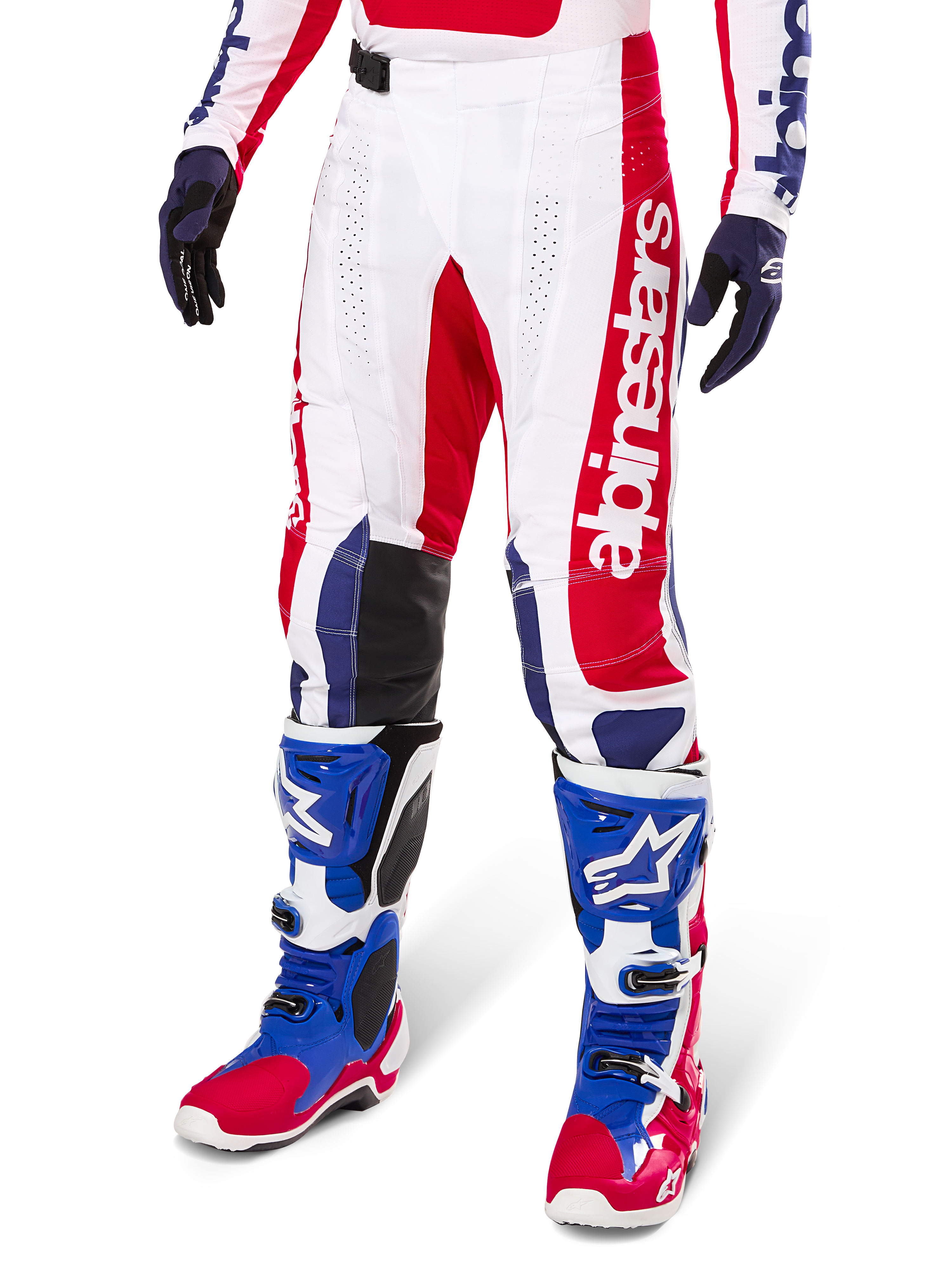Alpinestars Techstar Fortitude Edición Limitada, pantalones de motocross en rojo brillante, blanco y azul, usados con botas y guantes de off-road a juego, con marca vertical en la pierna, paneles perforados transpirables y secciones de rodilla reforzadas en negro, diseño de ajuste atlético de carrera