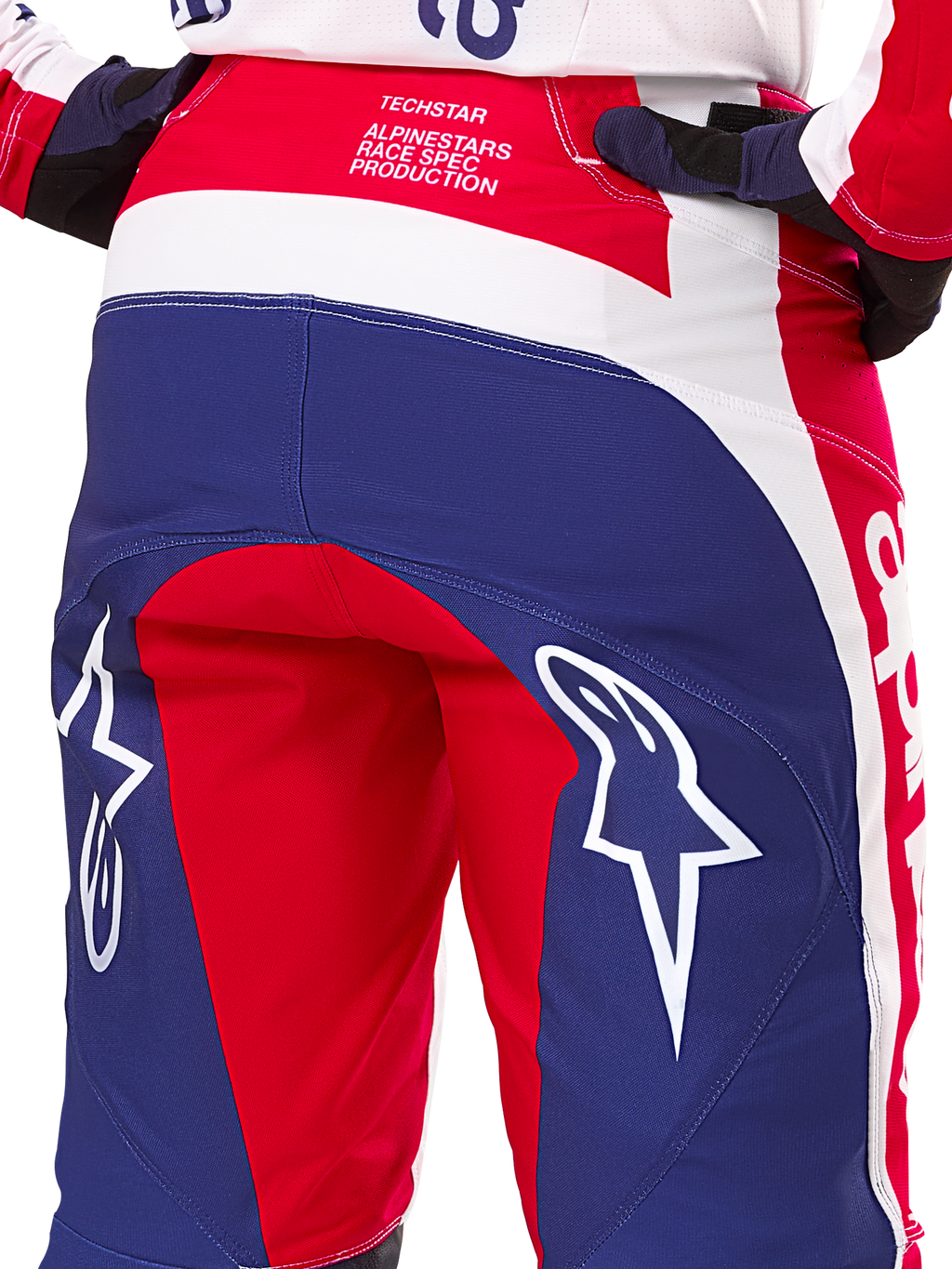 Alpinestars Limited Edition Techstar Fortitude Pants, pantalones de motocross, rojos, blancos y azules, vista trasera con grandes logotipos de estrellas blancas en el asiento y marca Techstar Race Spec, textiles de alto rendimiento para carreras todoterreno