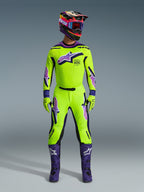 Alpinestars 2026 Supertech Vista Pants, pantalones de motocross, amarillo neón con detalles en púrpura y negro, usados como parte de un conjunto de equipación de carreras coordinado con jersey, casco y botas púrpuras a juego, con un ajuste atlético profesional y logotipos llamativos para rendimiento off-road