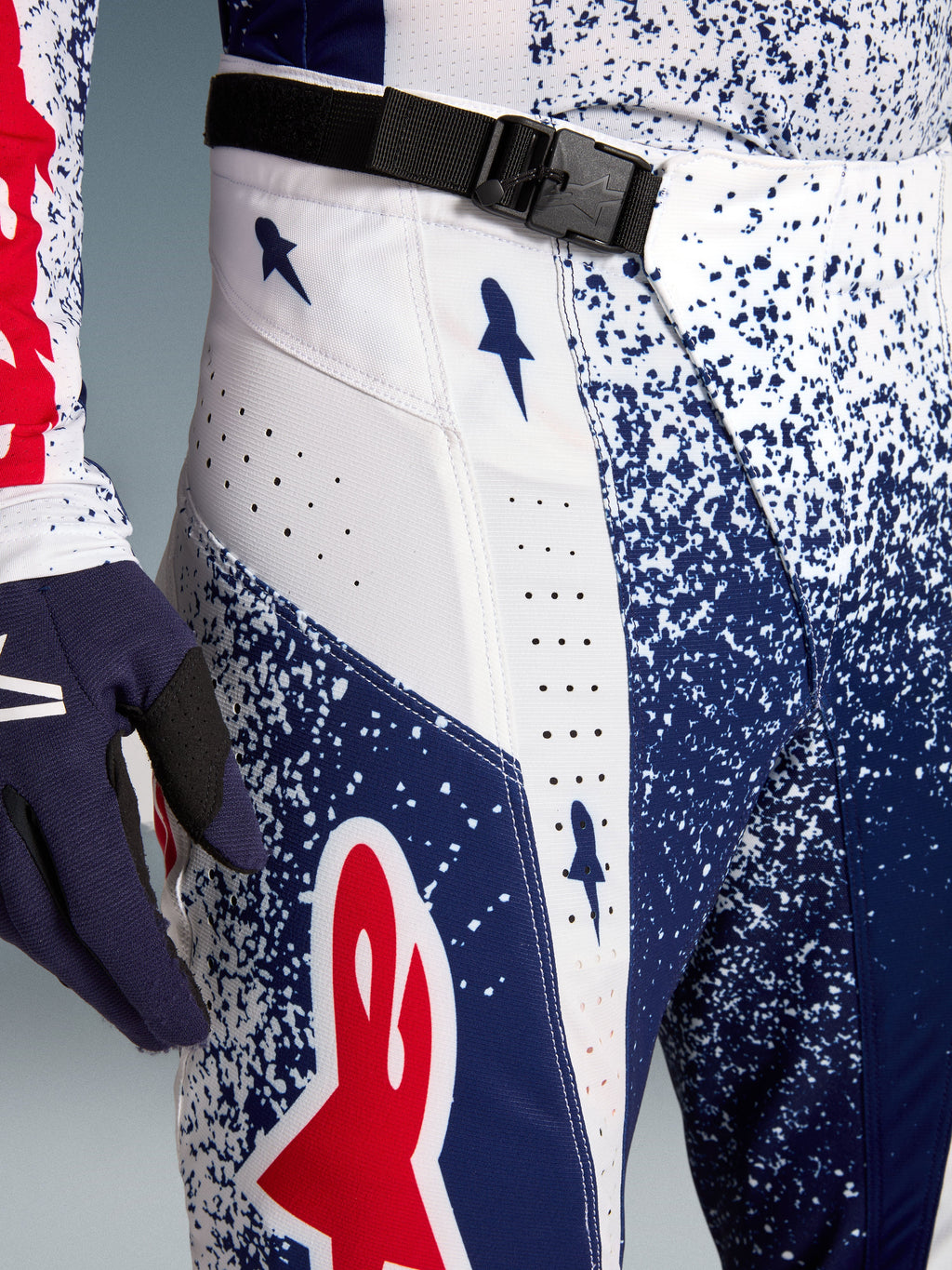 Alpinestars Techstar Unity Motocross Pants, blue and white speckled pattern with red logo and SX2 magnetic buckle.