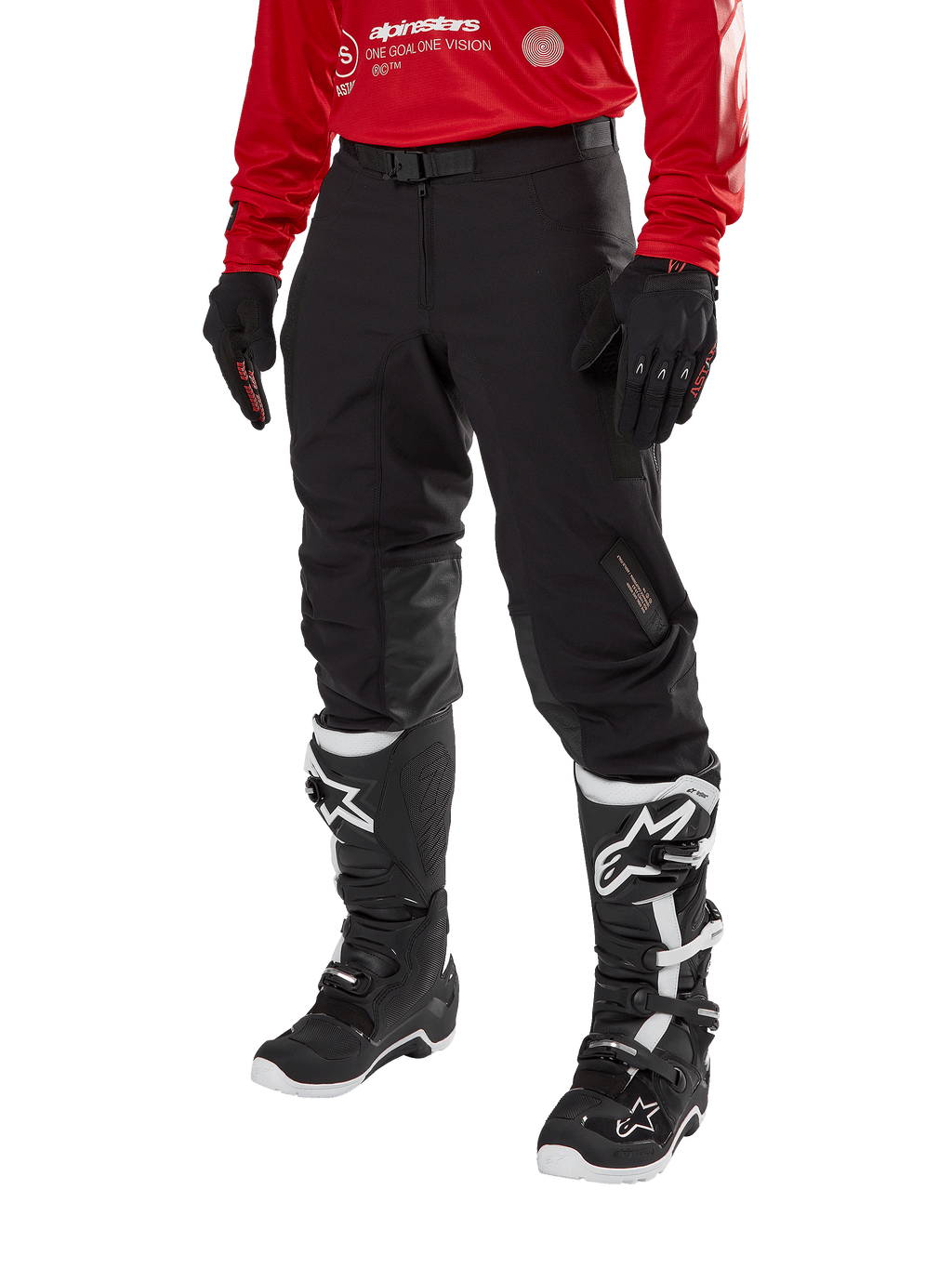 Alpinestars Techdura Pants, Black off-road motorcycle pants, worn with a red long-sleeve jersey and black and white motocross boots, featuring rugged stretch polyamide construction, leather inner knee reinforcements, and an adjustable buckled belt for enduro riding.