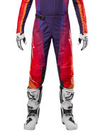 Alpinestars 2024 Techstar Pneuma Pants, pantalones de motocross para hombre, color morado, naranja y azul con diseño de degradado y logos blancos, mostrados con guantes blancos y botas de motocross blancas y negras.