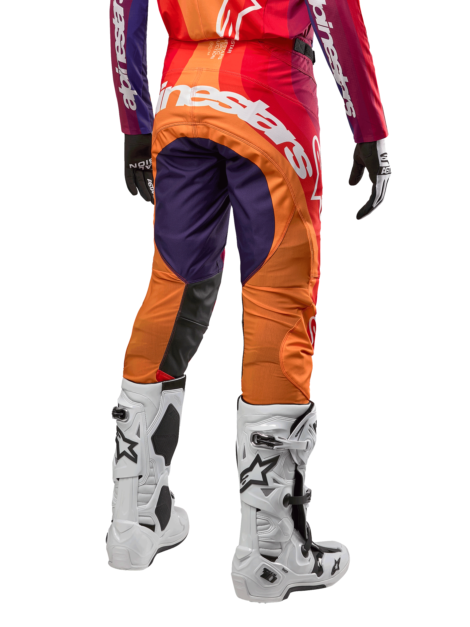 Alpinestars 2024 Techstar Pneuma Pants, pantalones de motocross para hombre, colores morado, naranja y azul profundo, vista trasera con logo blanco, combinados con botas blancas y guantes negros, material técnico y duradero para off-road
