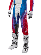 Alpinestars 2024 Techstar Pneuma Pants, pantalones de motocross, azul, rojo y blanco, usados con jersey a juego, botas y guantes de carreras blancos, diseño gráfico vibrante con detalles en rojo, azul y morado, perforados para transpirabilidad