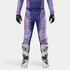 Alpinestars Techstar Ocuri Pants 2024, pantalones de motocross para hombre en color púrpura y naranja intenso, diseño deportivo con logotipos rojos, combinados con guantes negros y botas de motocross blancas y negras, equipamiento de alto rendimiento para off-road.