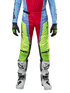 Alpinestars Techstar Ocuri 2024, pantalones de motocross, azul claro, amarillo flúor y rojo baya, usados con jersey a juego y botas de motocross blancas, con paneles vibrantes de bloques de color y logotipos negros, diseño duradero de ajuste de competición