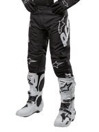 Alpinestars 2024 Racer Hana Pants, pantalones de motocross para hombre, negros con gráficos blancos, diseño ergonómico con logos de la marca, material ligero y duradero para alto rendimiento, mostrados con botas de motocross blancas