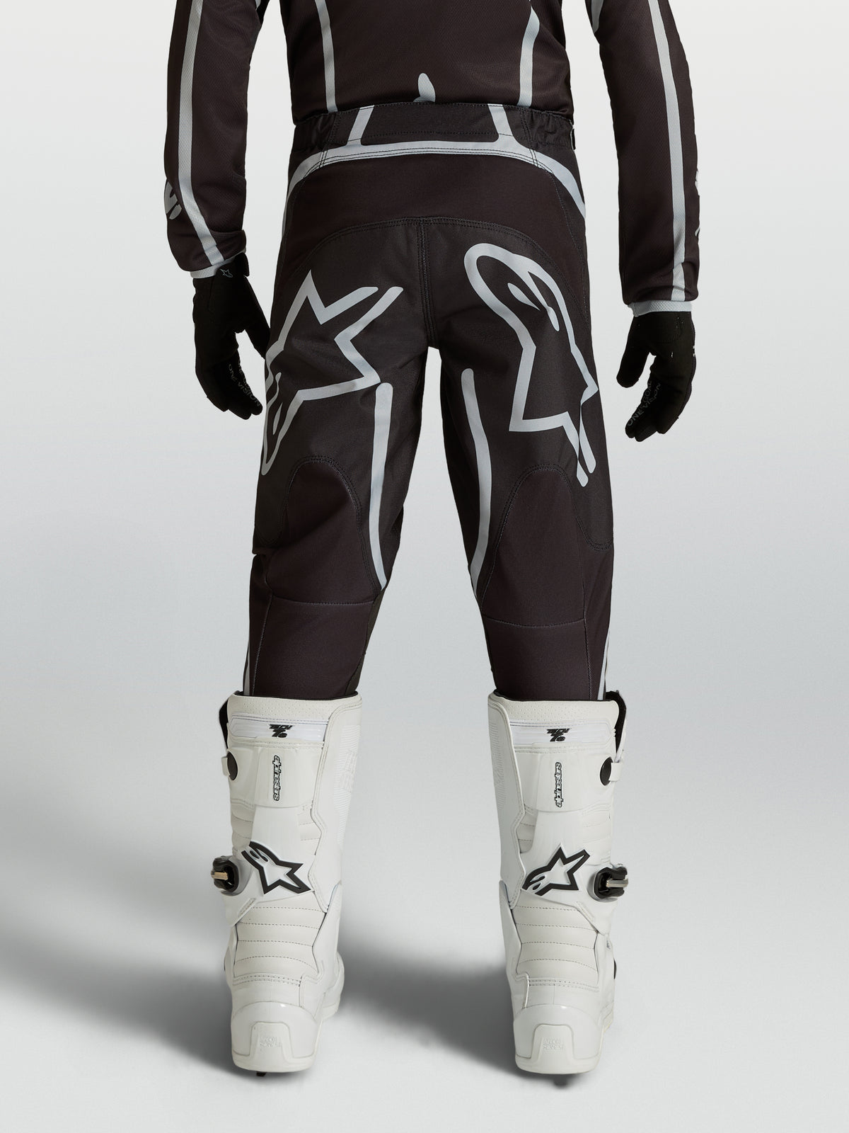Alpinestars Youth Fluid Apex V2 Pants, black and silver motocross racing gear with ergonomic rear fit and star logos.