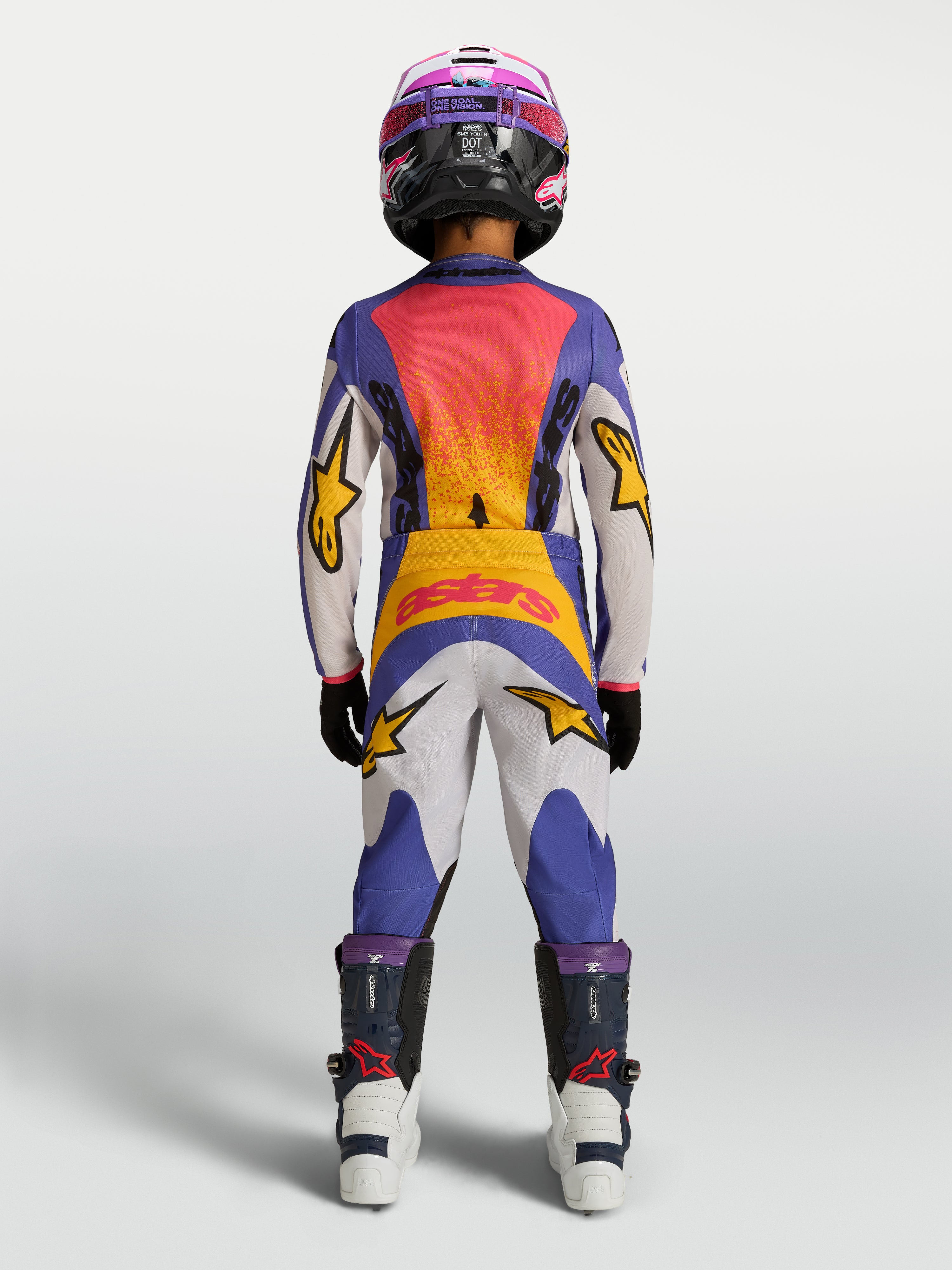 Alpinestars Pantalones Fluid Drag Juvenil, pantalones de motocross para off-road, juvenil, azules y blancos con detalles amarillos, vista posterior en modelo